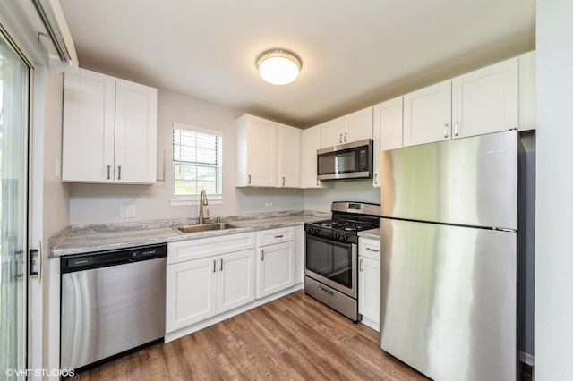 527 E Shagbark Ln Unit H, Streamwood, IL 60107 - kitchen featuring stainless steel appliances, wood finished floors, and white cabinetry