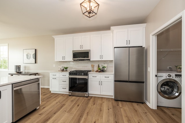 26615 W Captiva Ln, Plainfield, IL 60544 - kitchen with appliances with stainless steel finishes, washer / dryer, light countertops, light wood finished floors, and white cabinetry