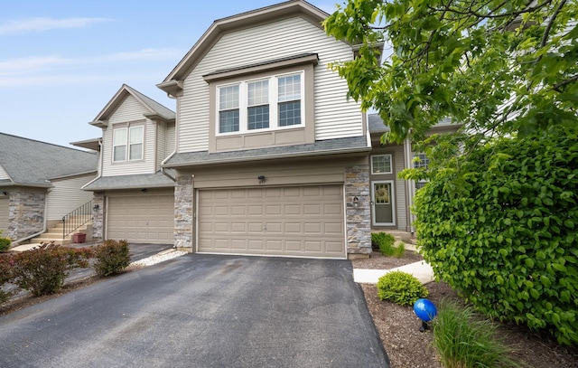 497 Metropolitan St, Aurora, IL 60502 - view of property with a garage, stone siding, asphalt driveway, and roof with shingles