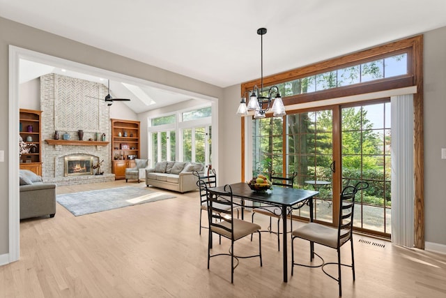 2731 Wolf River Ct, Naperville, IL 60565 - dining space with vaulted ceiling, wood finished floors, ceiling fan, a fireplace, and a chandelier