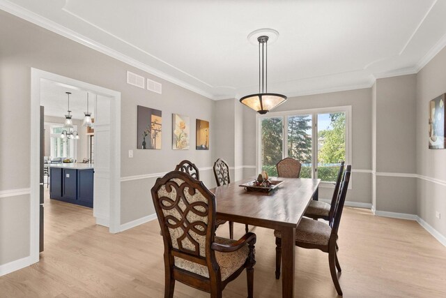 2731 Wolf River Ct, Naperville, IL 60565 - dining space featuring light wood-style floors, crown molding, baseboards, and a chandelier