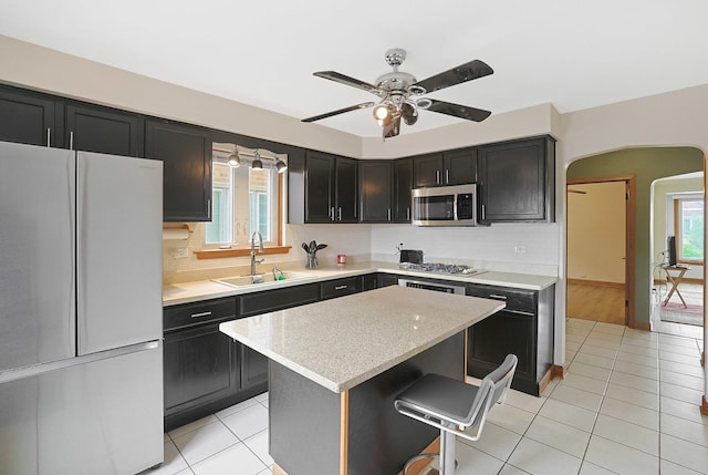 5531 S Mcvicker Ave, Chicago, IL 60638 - kitchen with appliances with stainless steel finishes, a sink, arched walkways, and dark cabinetry