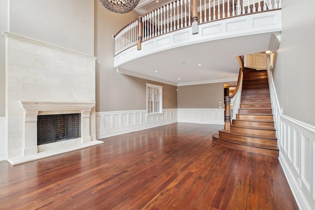 3926 N Greenview Ave, Chicago, IL 60613 - unfurnished living room featuring ornamental molding, wood finished floors, stairs, a fireplace, and a wainscoted wall