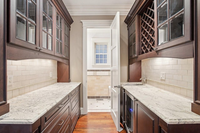 3926 N Greenview Ave, Chicago, IL 60613 - kitchen featuring dark brown cabinets, ornamental molding, a sink, and decorative backsplash