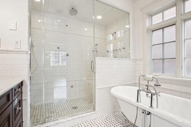 3926 N Greenview Ave, Chicago, IL 60613 - bathroom with tile walls, a soaking tub, a stall shower, vanity, and wainscoting