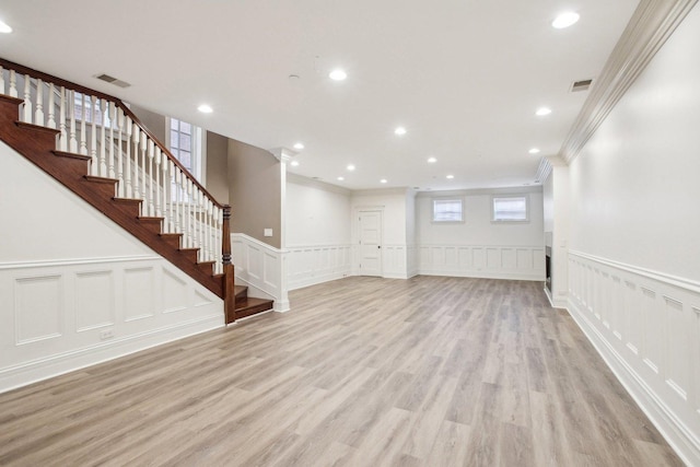 3926 N Greenview Ave, Chicago, IL 60613 - unfurnished living room with ornamental molding, a decorative wall, stairs, light wood finished floors, and a wainscoted wall