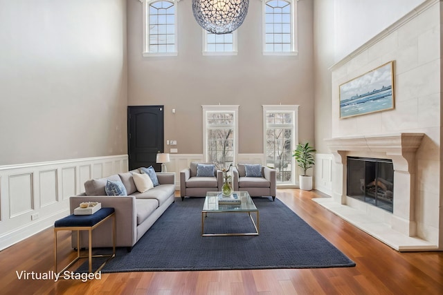 3926 N Greenview Ave, Chicago, IL 60613 - living area with a towering ceiling, a wainscoted wall, a tiled fireplace, and wood finished floors