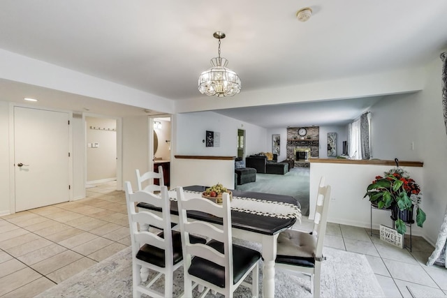 14828 W N Creek Ct, Homer Glen, IL 60491 - dining space with light tile patterned floors, a chandelier, and a fireplace