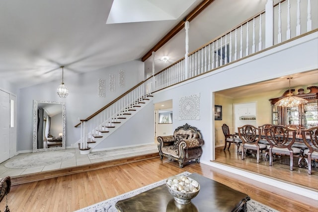 14828 W N Creek Ct, Homer Glen, IL 60491 - living room featuring wood finished floors, healthy amount of natural light, stairway, a high ceiling, and a chandelier