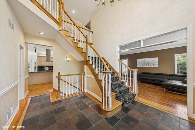 4332 Camelot Cir, Naperville, IL 60564 - staircase with healthy amount of natural light, crown molding, a high ceiling, baseboards, and wood finished floors