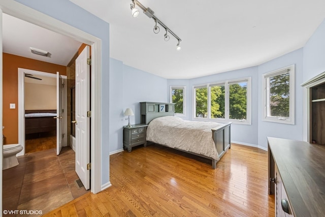 4332 Camelot Cir, Naperville, IL 60564 - bedroom with light wood-type flooring, rail lighting, and baseboards
