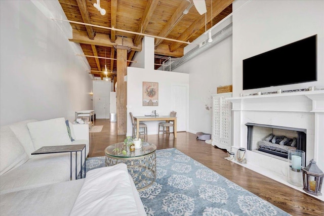 616 W Fulton St Unit 212, Chicago, IL 60661 - living area featuring wooden ceiling with exposed beams, a towering ceiling, a high end fireplace, wood finished floors, and a ceiling fan