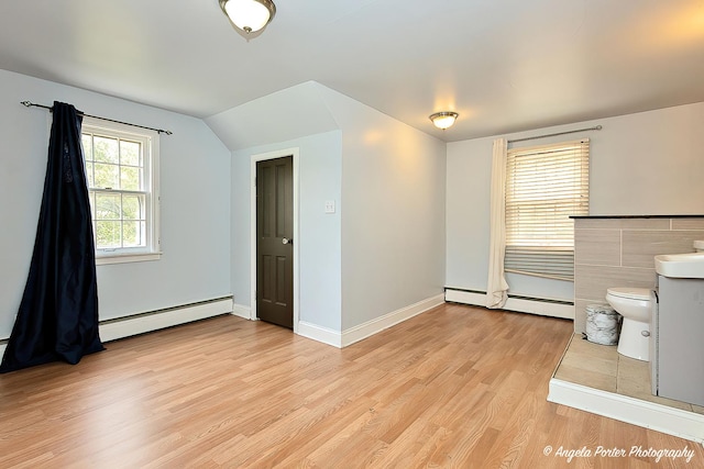 617 Colville Pl, Waukegan, IL 60087 - spare room featuring light wood-style floors, a baseboard heating unit, lofted ceiling, and baseboards