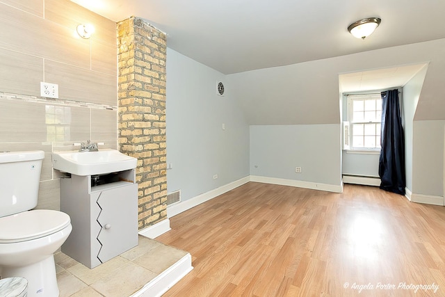 617 Colville Pl, Waukegan, IL 60087 - bathroom with toilet, a baseboard radiator, wood finished floors, lofted ceiling, and a sink