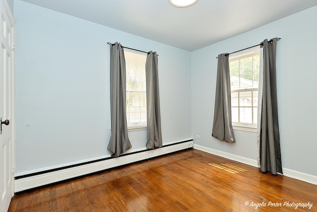 617 Colville Pl, Waukegan, IL 60087 - spare room featuring baseboard heating, wood finished floors, and baseboards