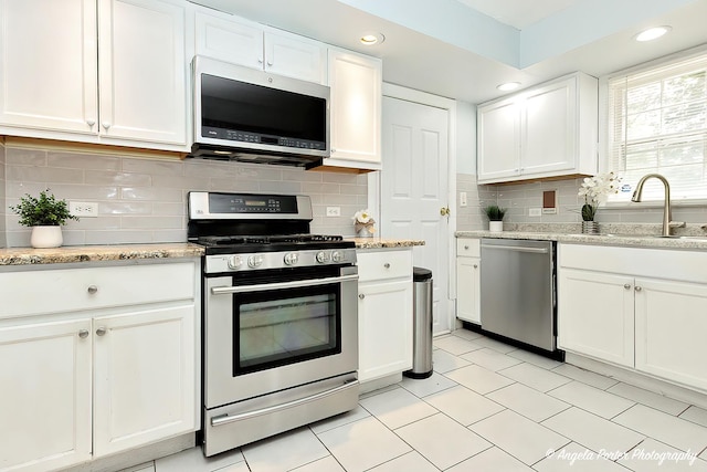 617 Colville Pl, Waukegan, IL 60087 - kitchen with appliances with stainless steel finishes, a sink, white cabinets, backsplash, and recessed lighting