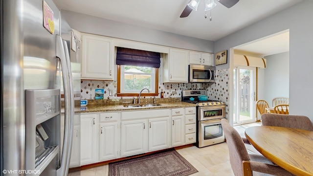 16101 Wabash Ave, South Holland, IL 60473 - kitchen with appliances with stainless steel finishes, a sink, a ceiling fan, white cabinets, and light stone counters