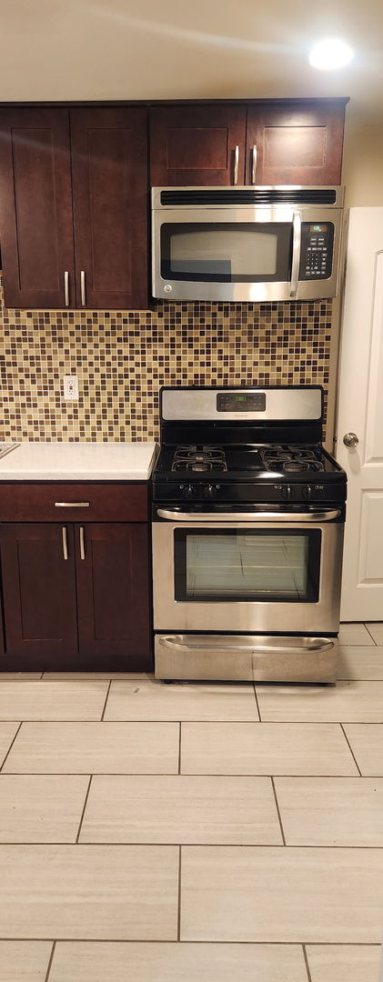 3538 Western Ave Unit 0, Park Forest, IL 60466 - kitchen with appliances with stainless steel finishes, light countertops, tasteful backsplash, and dark brown cabinets