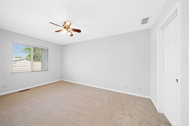 spare room featuring carpet floors, a ceiling fan, and baseboards
