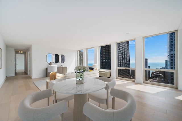 111 E Chestnut St Unit 40C, Chicago, IL 60611 - dining space featuring light wood-type flooring, a water view, and floor to ceiling windows