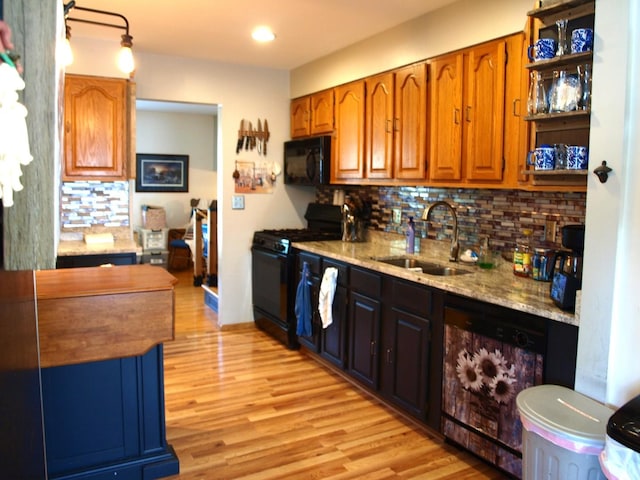 111 Magnolia Ln, Lindenhurst, IL 60046 - kitchen with black appliances, a sink, decorative backsplash, light wood finished floors, and light stone counters