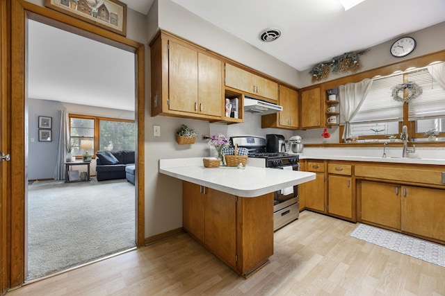 931 Sunset Rd, Wheaton, IL 60189 - kitchen with stainless steel gas range oven, open shelves, under cabinet range hood, and a peninsula