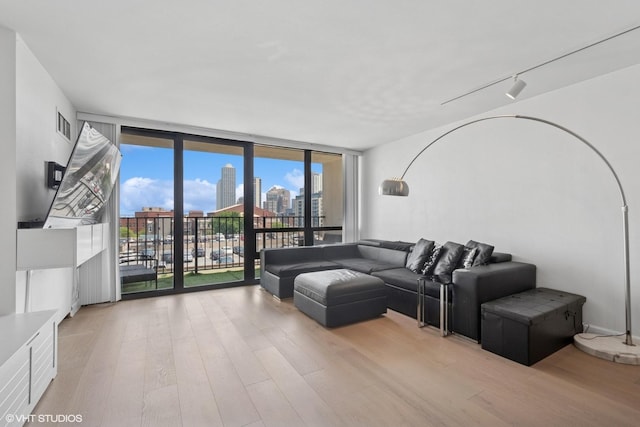 1636 N Wells St Unit 615, Chicago, IL 60614 - living room featuring a wall of windows, wood finished floors, rail lighting, and a city view