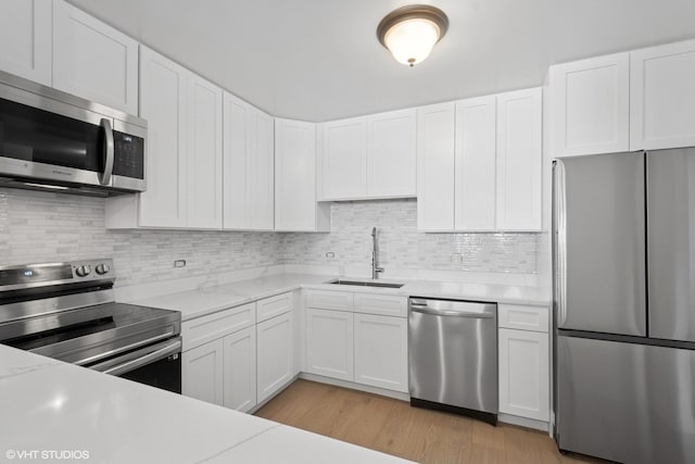 1636 N Wells St Unit 615, Chicago, IL 60614 - kitchen with stainless steel appliances, a sink, white cabinetry, and light wood-style flooring