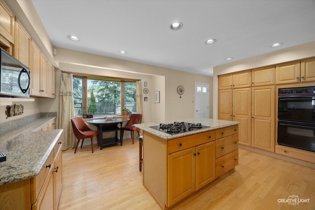 1903 Brentwood Ln, Wheaton, IL 60189 - kitchen with black appliances, light wood finished floors, recessed lighting, light stone countertops, and a kitchen island