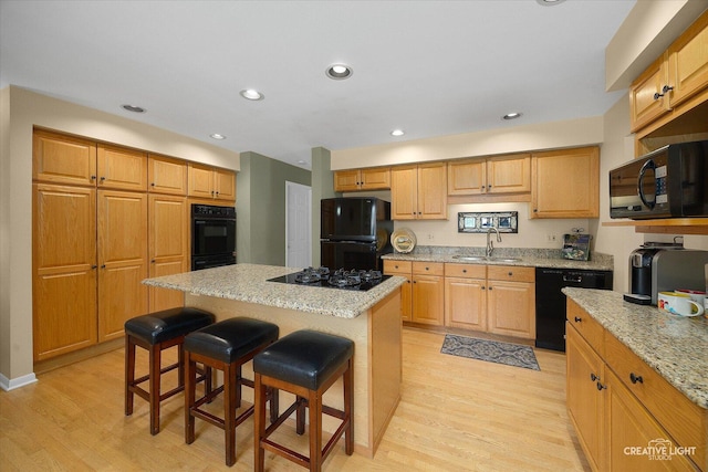 1903 Brentwood Ln, Wheaton, IL 60189 - kitchen featuring black appliances, light wood finished floors, a breakfast bar area, light stone countertops, and recessed lighting