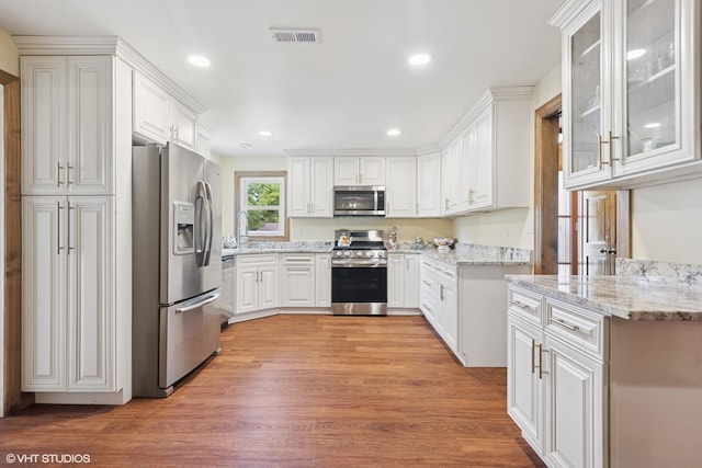 359 N Shady Ln, Elmhurst, IL 60126 - kitchen with stainless steel appliances, light wood-style floors, white cabinets, recessed lighting, and glass insert cabinets