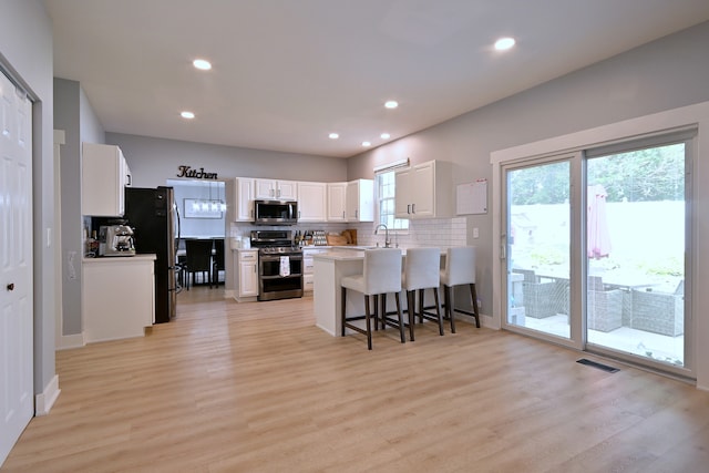 1422 Deer Creek Ln, Lake In The Hills, IL 60156 - kitchen with stainless steel appliances, tasteful backsplash, a peninsula, light wood-style flooring, and a breakfast bar