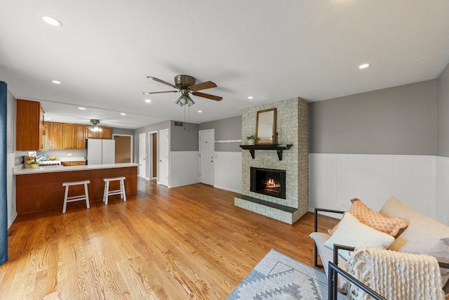 926 Navajo St, Carol Stream, IL 60188 - living area featuring ceiling fan, a fireplace, light wood-type flooring, recessed lighting, and wainscoting