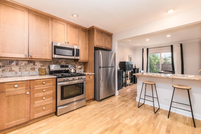 1023 Rene Ct, Park Ridge, IL 60068 - kitchen with stainless steel appliances, a kitchen breakfast bar, light wood-style floors, backsplash, and ornamental molding
