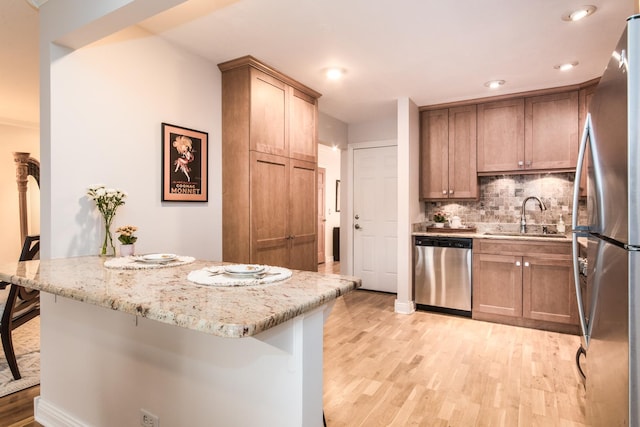 1023 Rene Ct, Park Ridge, IL 60068 - kitchen with stainless steel appliances, a sink, light wood-style floors, backsplash, and a breakfast bar