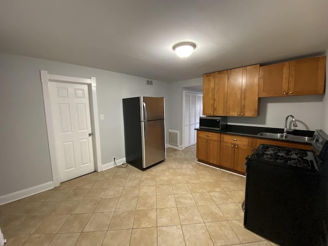4224 N Kimball Ave, Chicago, IL 60618 - kitchen featuring appliances with stainless steel finishes, a sink, dark countertops, brown cabinets, and baseboards