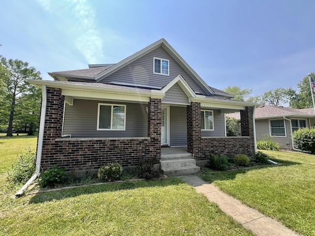 418 S Main St, Rankin, IL 60960 - bungalow-style home with brick siding, a porch, and a front lawn