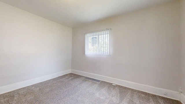 418 S Main St, Rankin, IL 60960 - empty room featuring dark colored carpet and baseboards
