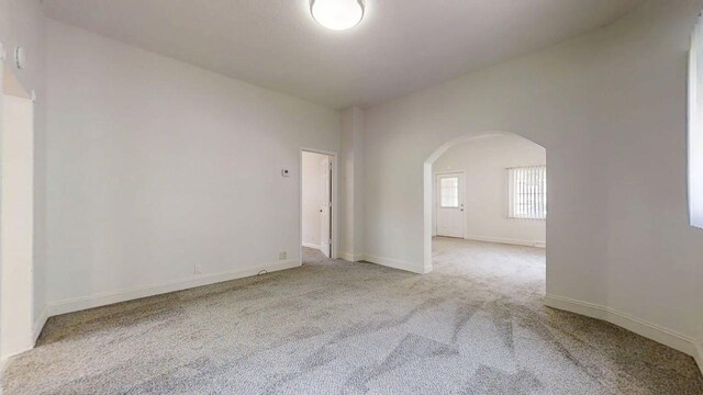 418 S Main St, Rankin, IL 60960 - empty room featuring arched walkways and carpet