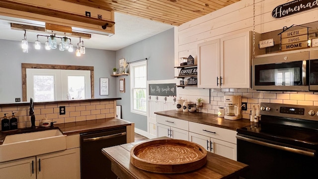 2703 Westbrook Dr, Bloomington, IL 61705 - kitchen with stainless steel appliances, a sink, open shelves, butcher block counters, and decorative backsplash