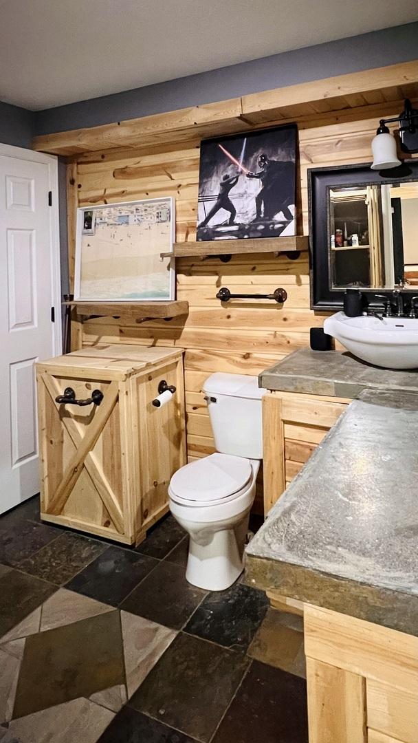 2703 Westbrook Dr, Bloomington, IL 61705 - bathroom featuring toilet, a sink, wood walls, and stone finish floors