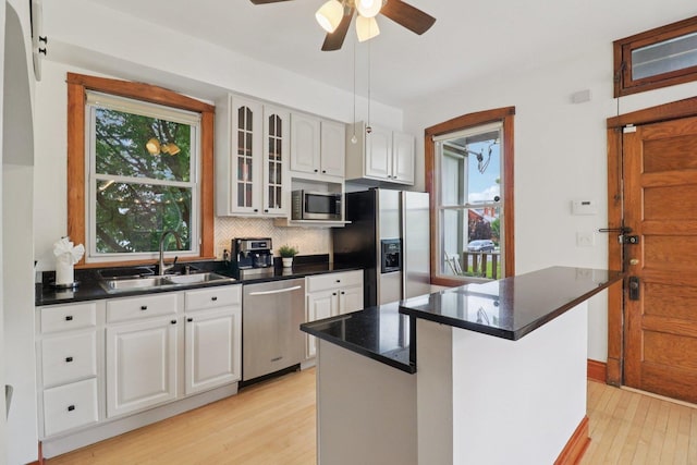 2559 N Saint Louis Ave, Chicago, IL 60647 - kitchen featuring stainless steel appliances, light wood-type flooring, plenty of natural light, and decorative backsplash