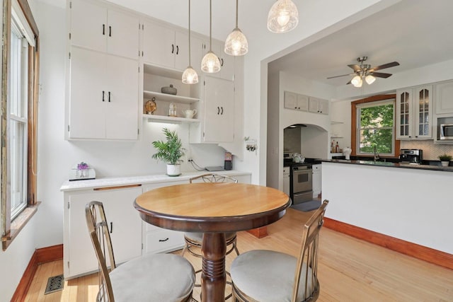 2559 N Saint Louis Ave, Chicago, IL 60647 - dining space featuring light wood-style flooring, arched walkways, and ceiling fan