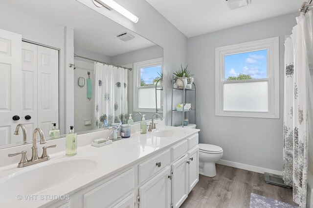 1981 White Oak Dr, Algonquin, IL 60102 - bathroom with toilet, double vanity, curtained shower, wood finished floors, and baseboards