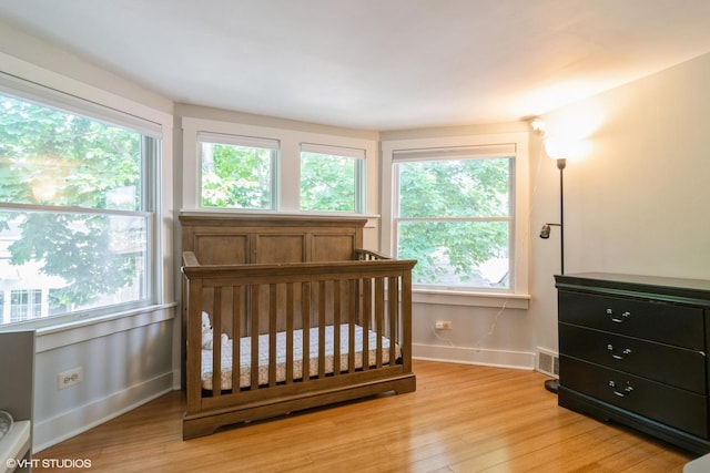 2617 Thayer St, Evanston, IL 60201 - bedroom featuring light wood-style floors, multiple windows, and a nursery area
