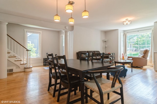 2617 Thayer St, Evanston, IL 60201 - dining room featuring decorative columns, healthy amount of natural light, light wood-type flooring, and stairs