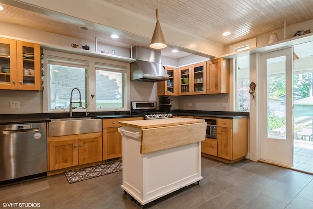 2617 Thayer St, Evanston, IL 60201 - kitchen featuring stainless steel appliances, butcher block counters, wall chimney exhaust hood, recessed lighting, and glass insert cabinets
