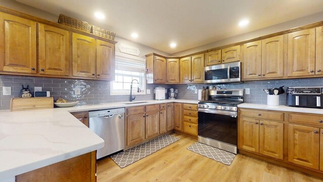1313 W Ridge Ln, Champaign, IL 61822 - kitchen featuring appliances with stainless steel finishes, light wood-style floors, backsplash, brown cabinetry, and recessed lighting