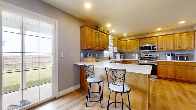 1313 W Ridge Ln, Champaign, IL 61822 - kitchen featuring stainless steel appliances, decorative backsplash, light wood-style flooring, brown cabinets, and recessed lighting