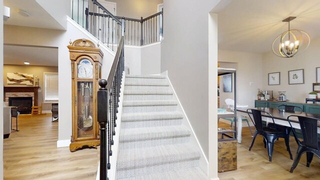 1313 W Ridge Ln, Champaign, IL 61822 - stairs featuring wood finished floors, a chandelier, and a fireplace